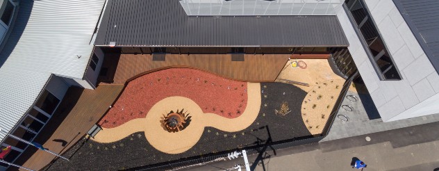 Drone footage of exterior of health hub, showing garden shaped like Aboriginal flag