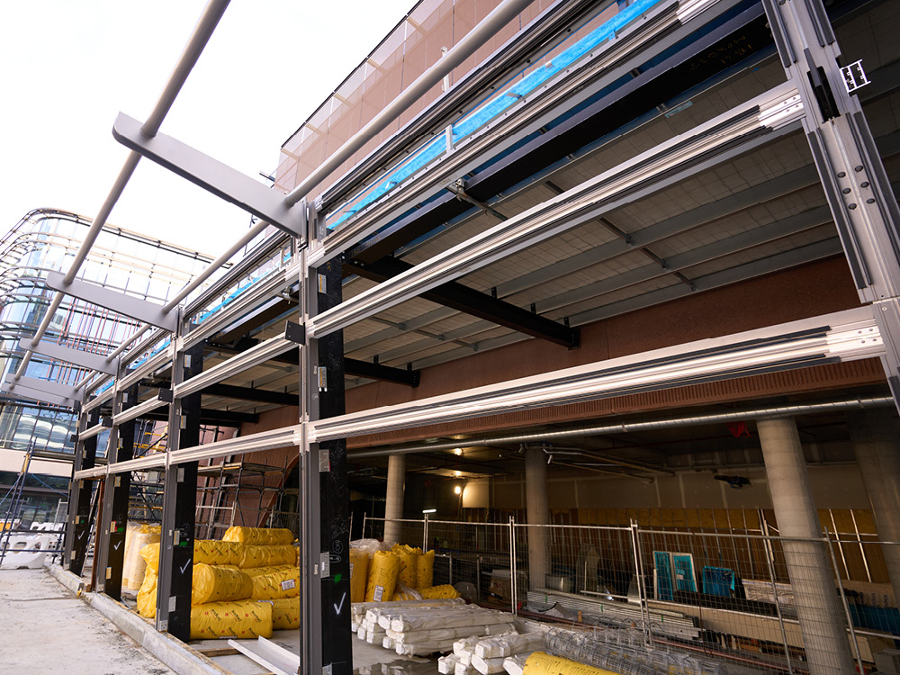 Cladding attached to the exterior of a building, with building materials on the ground underneath