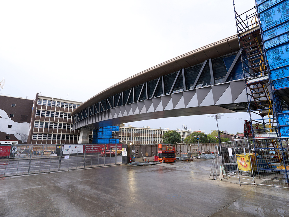 Large grey footbridge stretched across a busy road