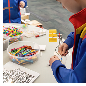 A young boy plays is immersed as he creates a model using wires and modelling equipment