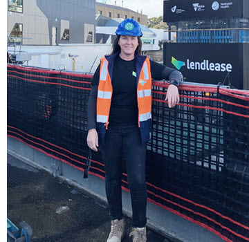 A photo of Kellie King, a construction worker at Lendlease. She is wearing a high-vis vest and helmet.