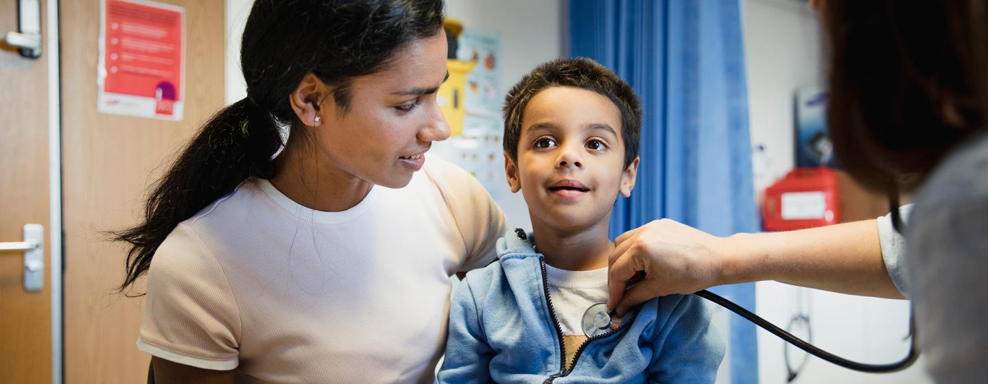 A doctor consulting with a young boy and his mother