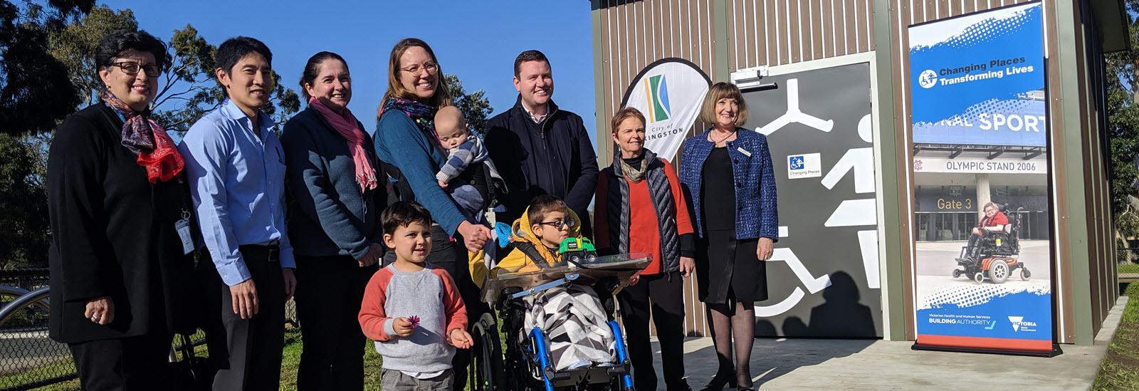 Families posing for a photo in front of the new Changing Places facility