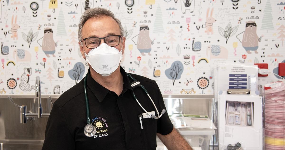 Image of A/Prof David Krieser standing against a colourful background within the Sunshine Hospital children’s emergency department 