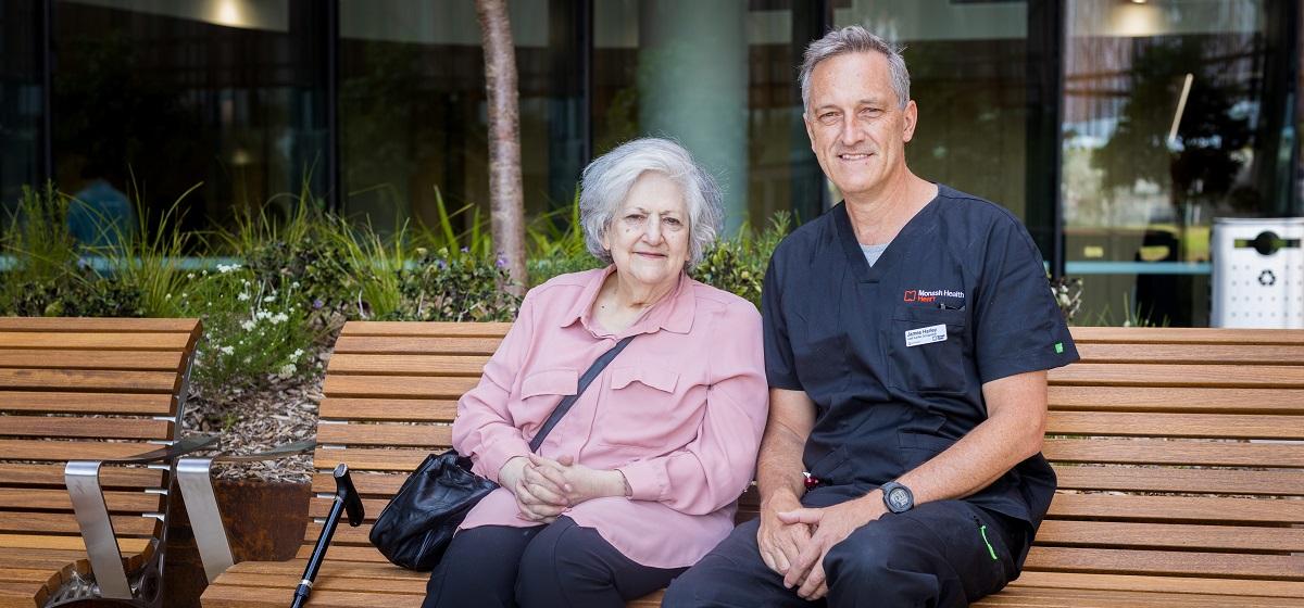 Elderly patient sitting with a staff member wearing scrubs at the Victorian Heart Hospital