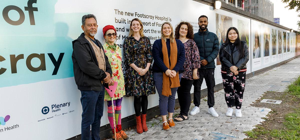 Community members smile proudly infront of the new Footscray Hospital 'Faces of Footscray' installation