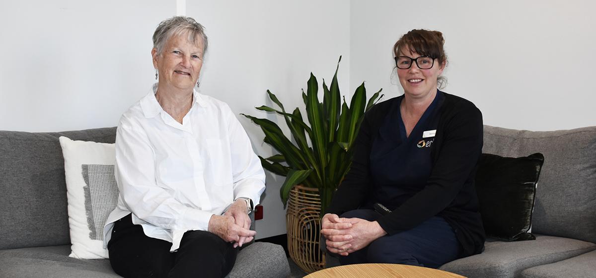 Two women sitting side by side smiling and looking relaxed