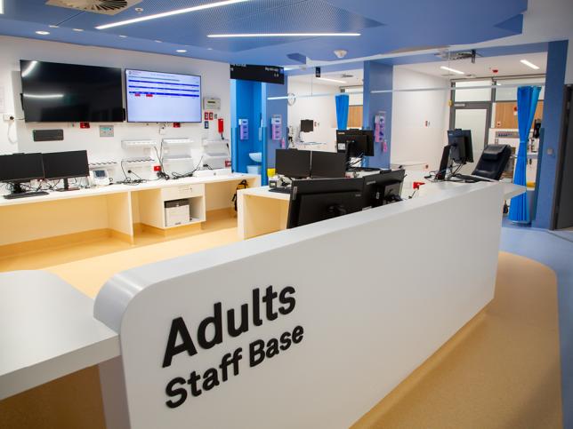 A staff base area inside an emergency department, with a sign reading 'Adults staff base'