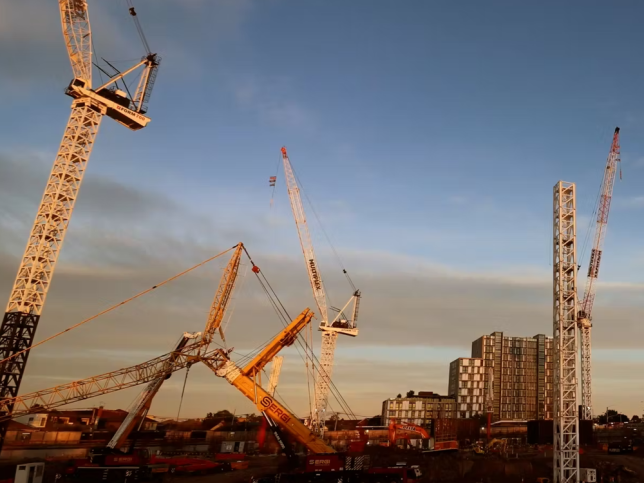 Cranes working on a building site at dusk