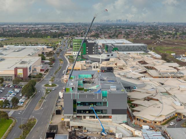 Aerial view of cranes installing a module on a hospital