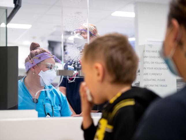 Photo of a young boy being carried into the children's emergency department at Sunshone Hospital. 