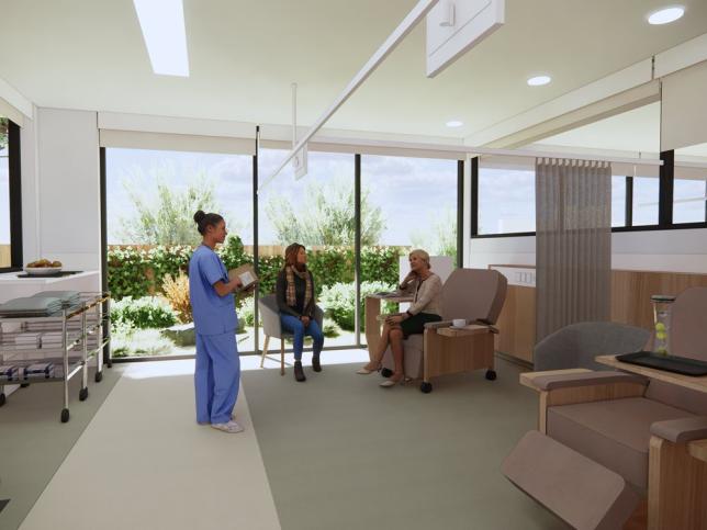 A nurse standing and talking to a patient sitting in a recliner chair at the Echuca Cancer and Wellness Centre