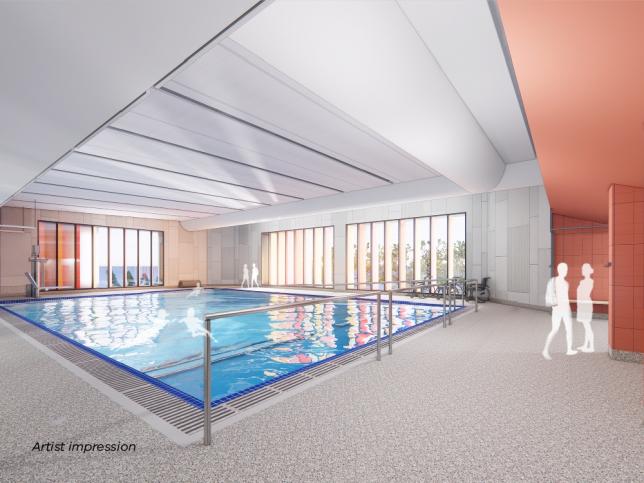 The hydrotherapy pool at the Bendigo Hospital Day Rehabilitation Centre. There is a large blue pool and people walking out of a room.