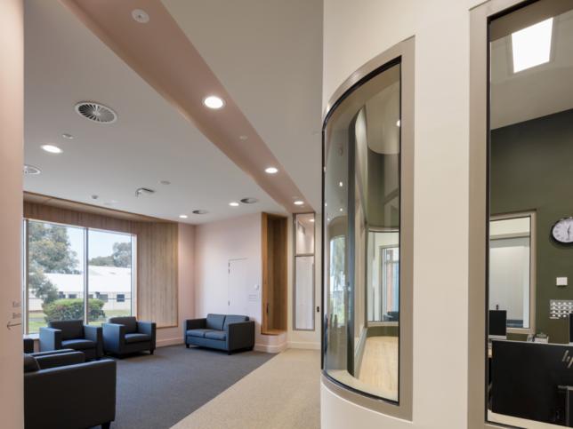 Patient lounge area with several couches and large windows at the Thomas Embling Hospital.