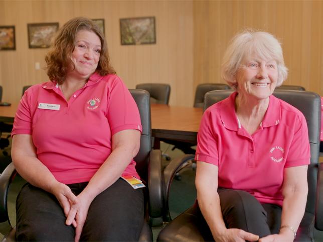 Two members of the Frankston Hospital 'Pink Ladies' - they are wearing pink polo tops.