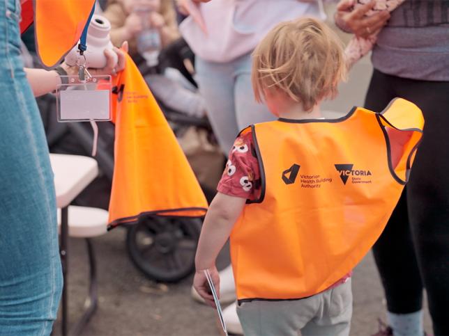 A young child wearing an orange high vis vest at a new Melton Hospital community information event