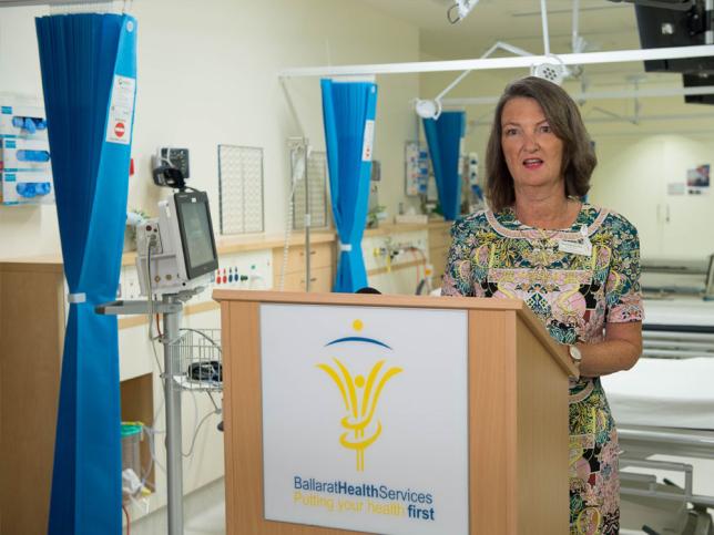 A woman speaks at a lectern in the cardiac catheterisation laboratory at Ballarat Base Hospital