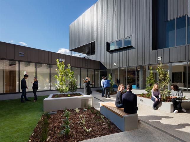 People sitting in the outdoor courtyard of the Clare Moore Building