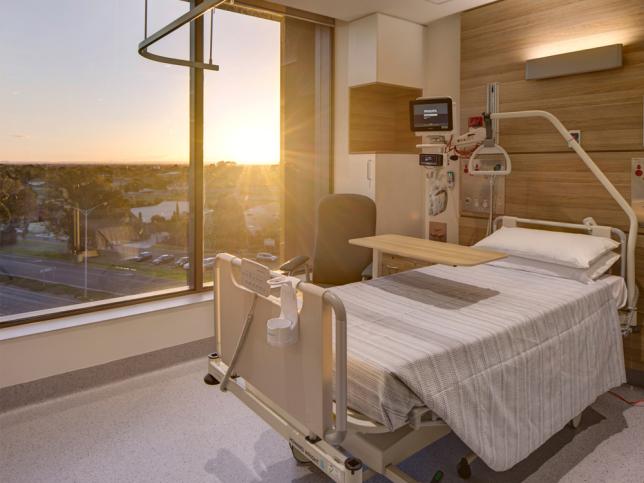 View of inpatient room, with bed and large window in the background