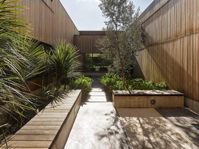 Wooden benches surrounded by various plants in a small courtyard area