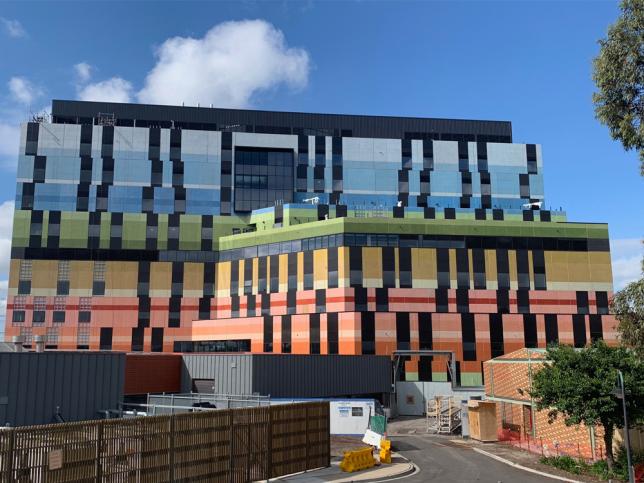 Facade of the new Joan Kirner Women's and Children's Hospital, which is coloured in blue, green, yellow, red and orange (from top to bottom)