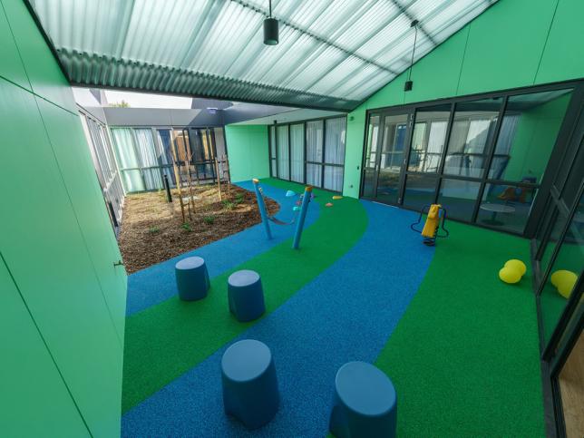 An undercover children's play area with blue and green decor