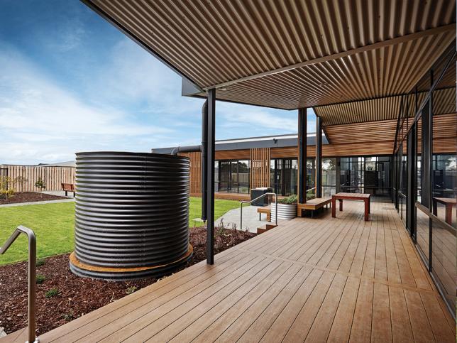 Wooden outdoor deck with corrugated covering and a water tank