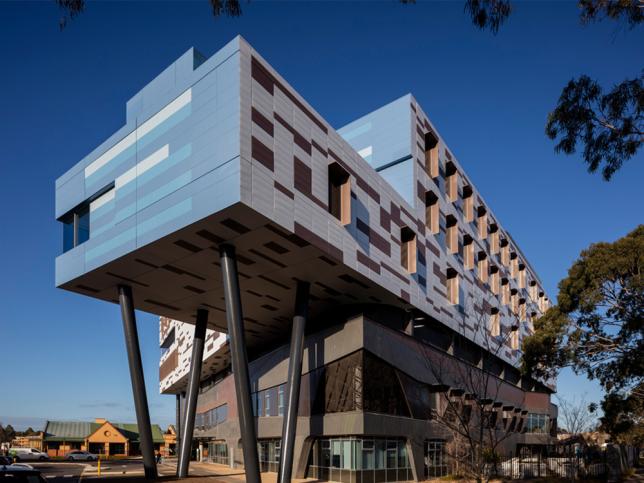 A view of the Werribee Mercy Hospital facade, with poles supporting a section that extends out