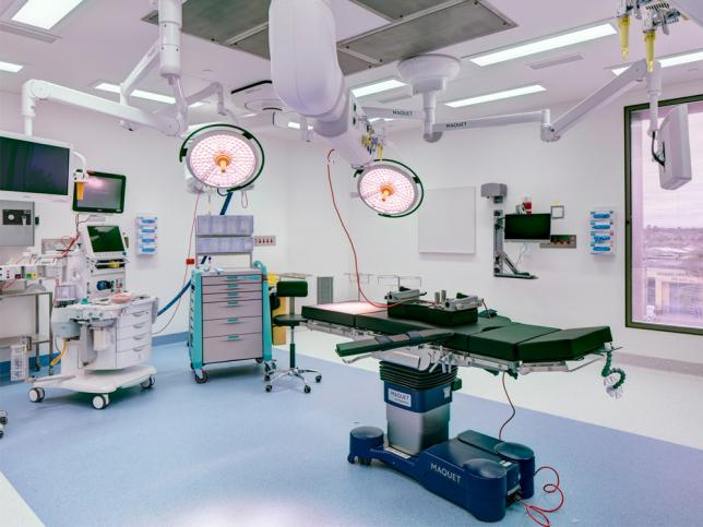 An operating theatre with equipment and overhead lights switched on