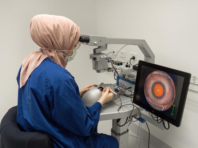 A woman looks into medical equipment