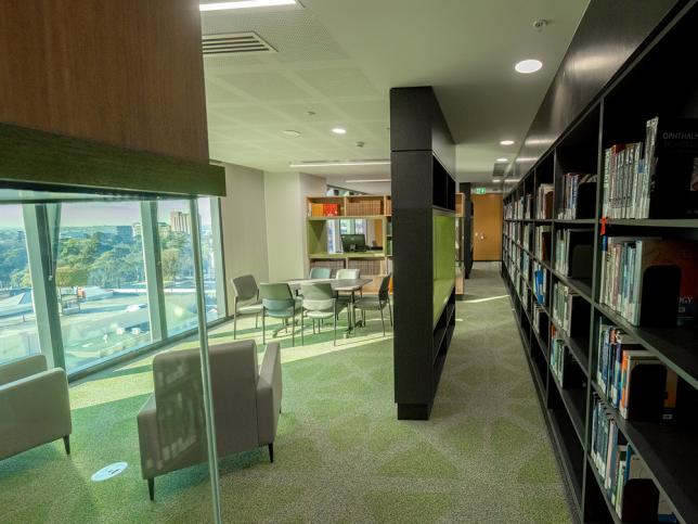 A library with chairs, tables and bookshelves