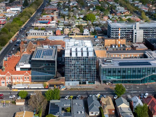 Aerial view of completed building with distinct grid pattern nestled among other hospital buildings