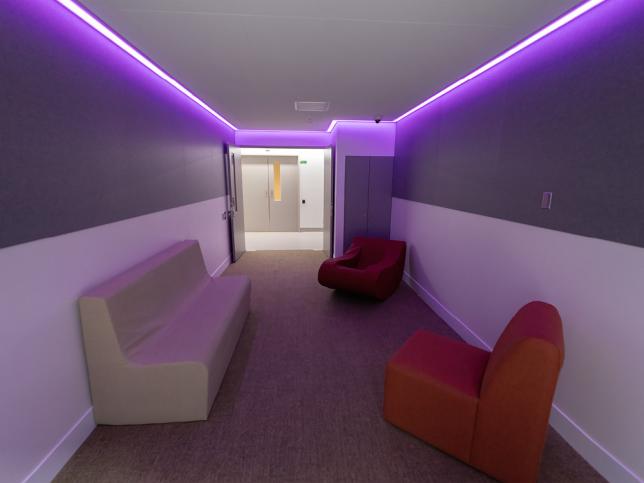 A room with couches lit in purple light