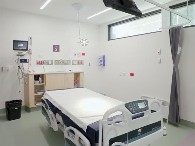 A clean and modern looking space with lots of natural light and a hospital bed