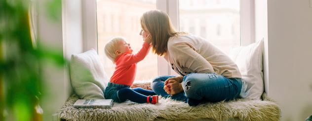 Mother and child playing on a window seat