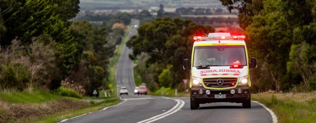 An ambulance driving along a country road