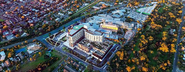 Aerial artist impression shows hospital with trees and park nearby