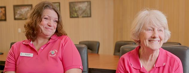 Two members of the Frankston Hospital 'Pink Ladies' - they are wearing pink polo tops.