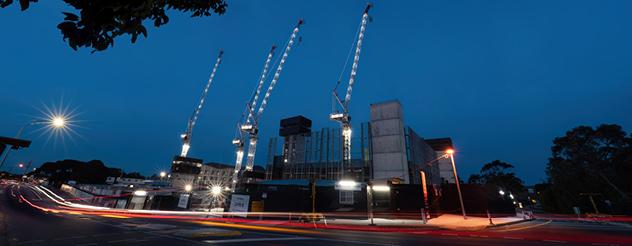 View of Frankston Hospital redevelopment at night including four tower cranes