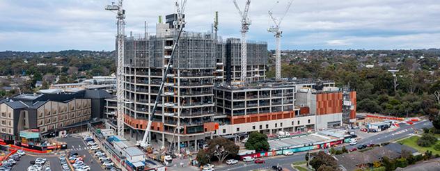 An aerial view of the exterior of Frankston Hospital, with cranes and scaffolding visible