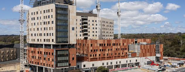 View of construction site where a brown and cream facade is taking place