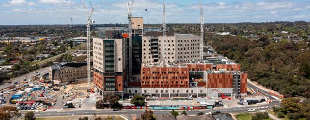 View of tower cranes framing the Frankston Hospital redevelopment construction site