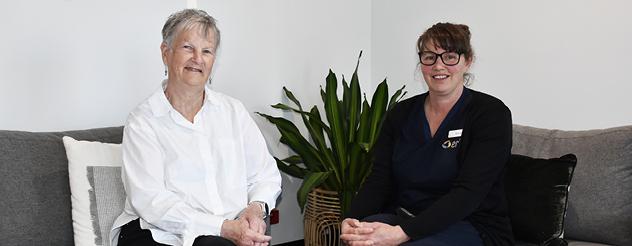 Two women sitting side by side smiling and looking relaxed